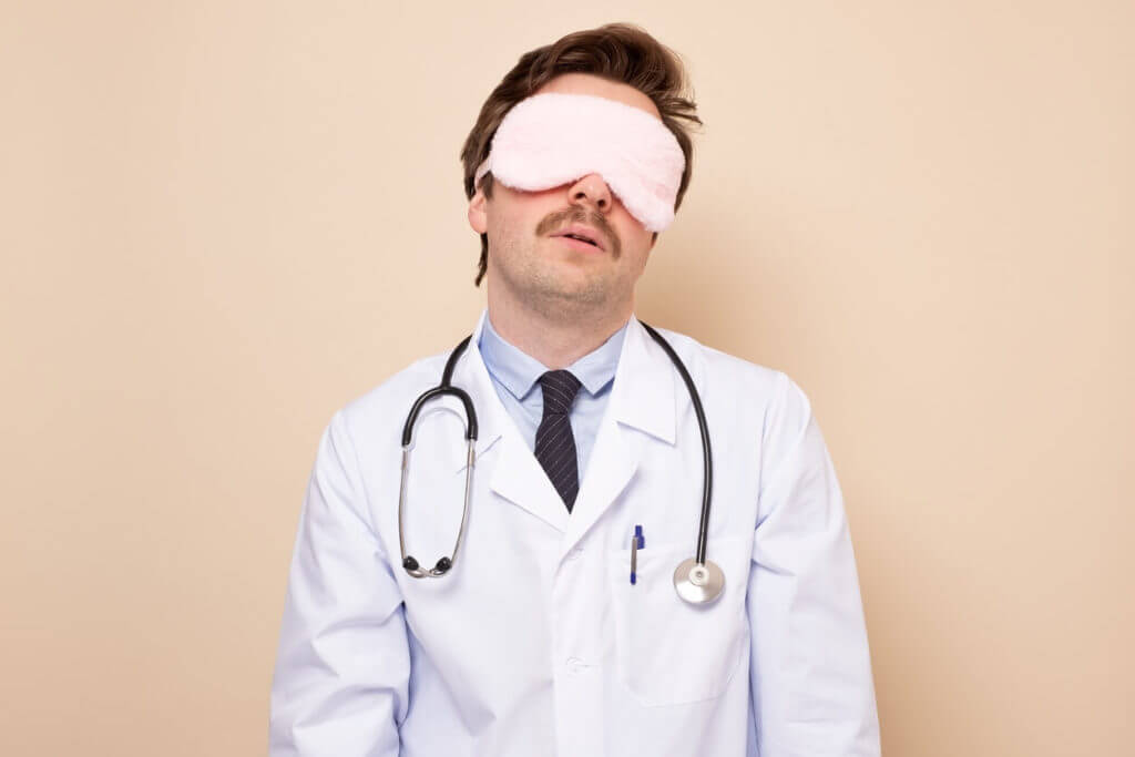 A man in a sleeping mask to illustrate a sleep doctor.