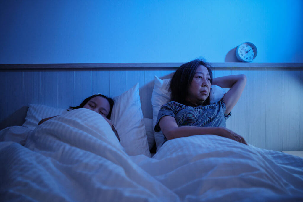 An Asian single mom woke up all night in a bedroom with insomnia.