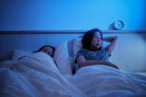 An Asian single mom woke up all night in a bedroom with insomnia.