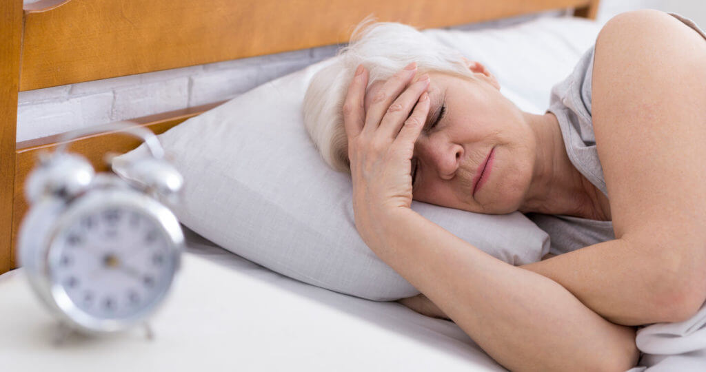 Senior woman suffering from insomnia in bed.
