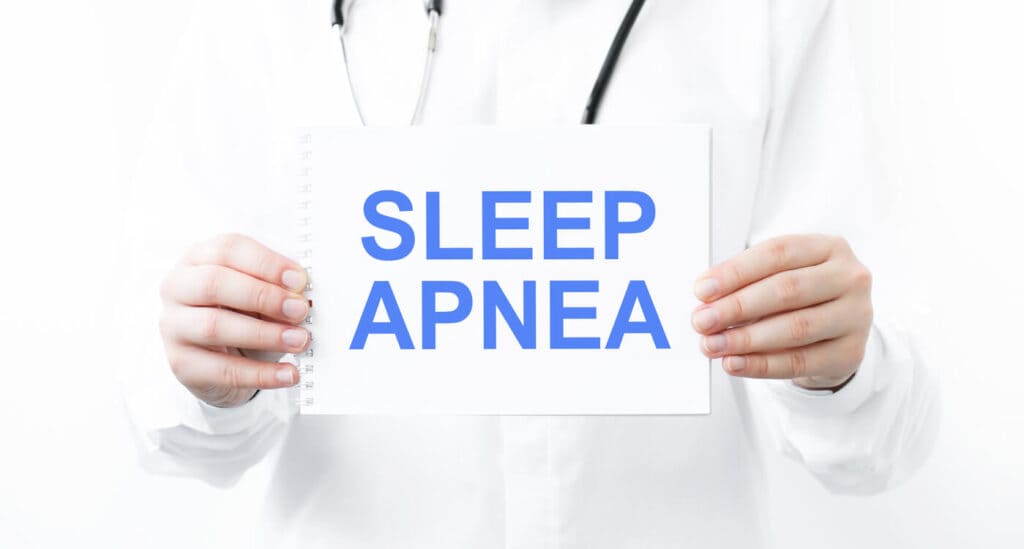 SLEEP APNEA text on white paper in the hands of a doctor